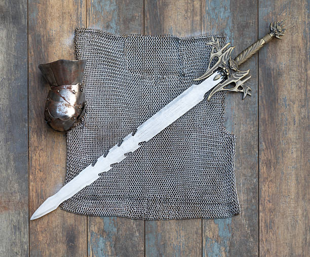 medieval chainmail and sword on a wooden background