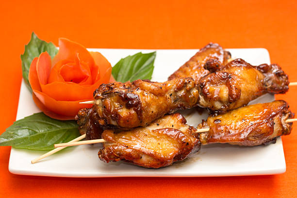 istock Barbecue Chicken Wings on Skewers with Tomato Rose Garnish 2242866421