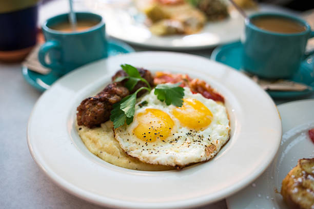 Sunny Side Up Eggs with Sausage and Grits on Breakfast Plate