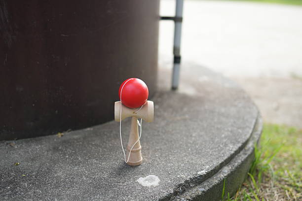 istock A red ball sits on a wooden stick on a cement surface 2242867107