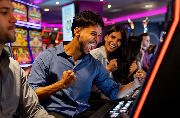 istock Excited man celebrating while winning on a slot machine at a casino 2242868677