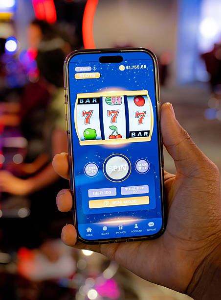 istock Man showing a gambling app while holding a cell phone at a casino 2242868709