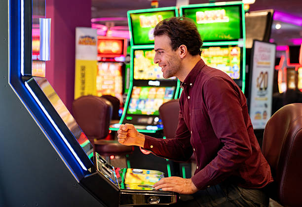 istock Excited man celebrating while winning on a slot machine at the casino 2242868742