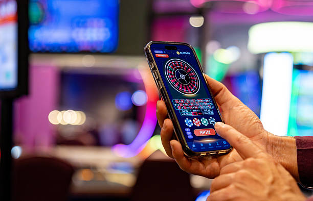 istock Man playing the roulette on a cell phone at a casino 2242868769
