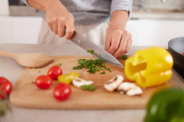 istock Woman chopping fresh vegetables on kitchen cutting board 2242871927