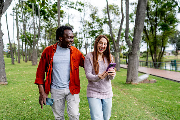 istock Friends sharing moment with mobile phones in park 2242872948