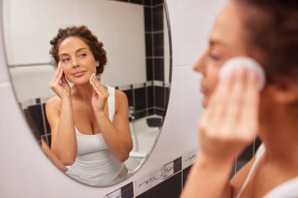 istock Woman cleansing face with cotton pads in bathroom 2242873236