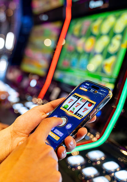 istock Gambler playing a slot machine game on his cell phone 2242876121