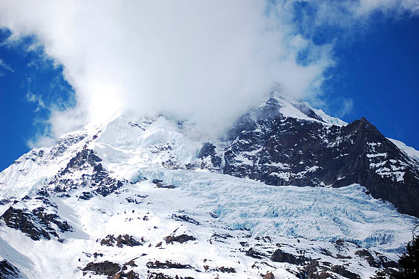 istock Snow-covered mountain peak with clouds surrounding it in a scenic view 2242892715