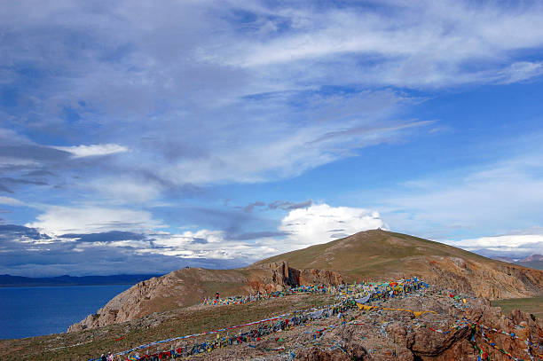 A picturesque scene of a mountain with colorful prayer flags under a clear blue sky, showcasing natural beauty and serene outdoor landscape.