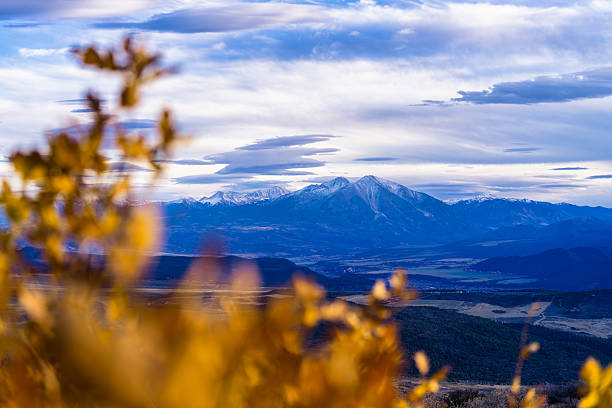 Autumn view of Mt. Sopris in the Elk Mountains near Glenwood Springs, Colorado USA. View of peak along with Capitol Peak at left with overcast cloudy skies and autumn leaf color in out of focus foreground.