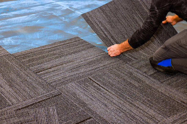 istock Installation of grey carpet tiles in modern office setting 2242897582
