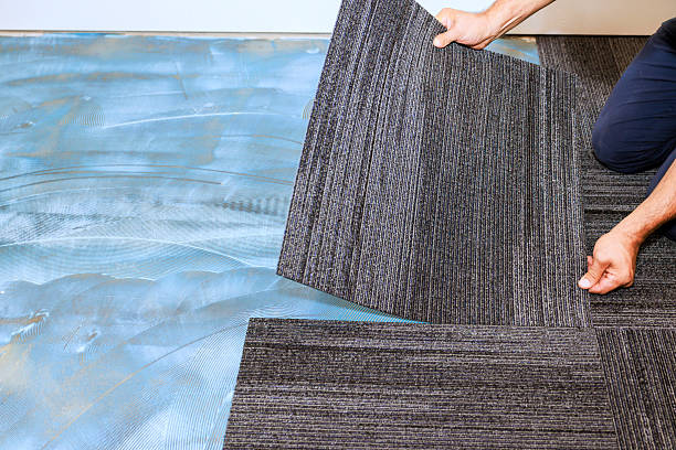 istock Installing gray carpet tiles in modern room during home renovation 2242897588