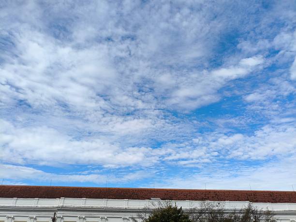Blue sky with fluffy White clouds above old building