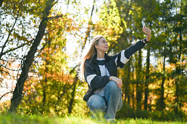 istock Young woman taking a selfie in park during autumn 2242904245