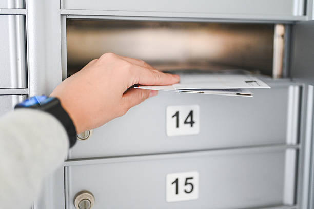 istock Hand retrieving mail from residential mailbox slot 2242904261