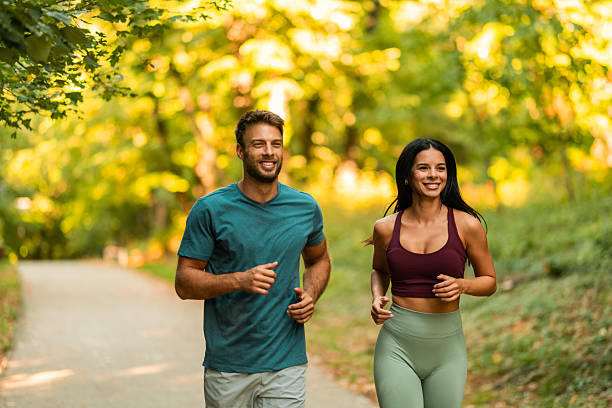 istock Cheerful athletic couple jogging through the park. 2242910195