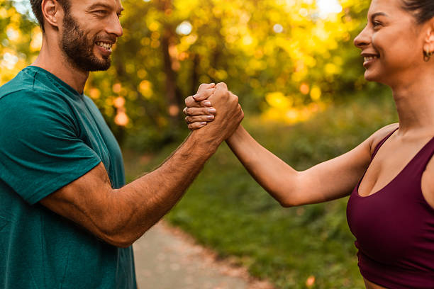 istock Cheerful athletic couple giving each other high five while exercising together in the park. 2242910676