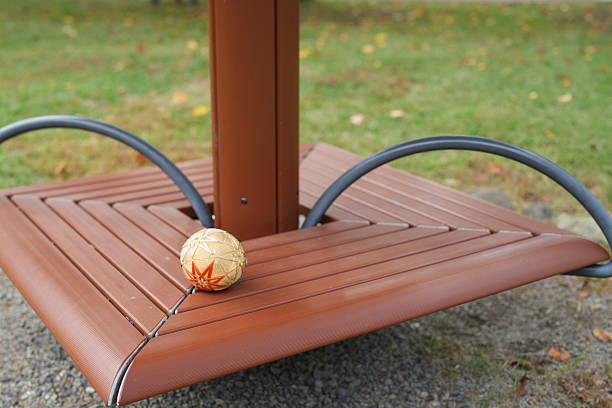 A brown bench with a ball on top of it