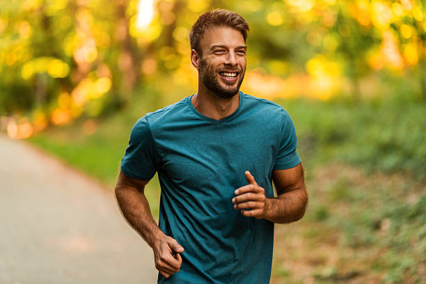 istock Athletic man jogging through the park. 2242912770