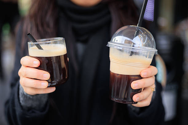 Environmental issue - Lady holding coffee in glass cup and plastic disposable cup
