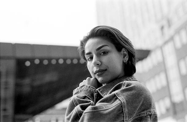 istock Young woman posing with denim jacket in urban setting, monochrome portrait 2242913882
