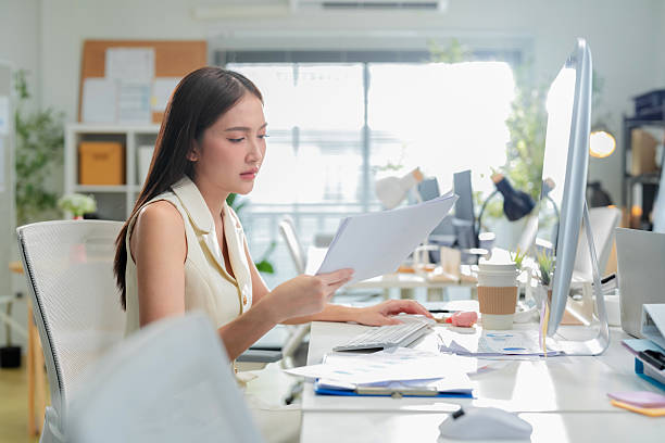 istock Young businesswoman is actively using a computer at her desk in the office. She's focused on working on the computer in the office, showcasing her professional dedication 2242914033