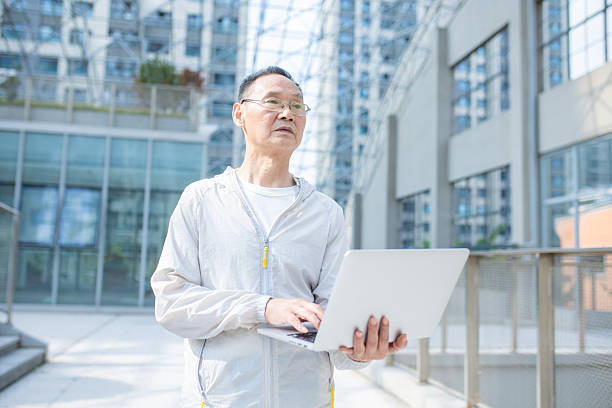 istock An Asian elderly freelancer using a laptop outdoors 2242917311