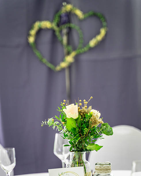 istock The view falls on a round table, covered with a pristine white tablecloth and set for a celebration, probably a wedding or an anniversary. 2242919877