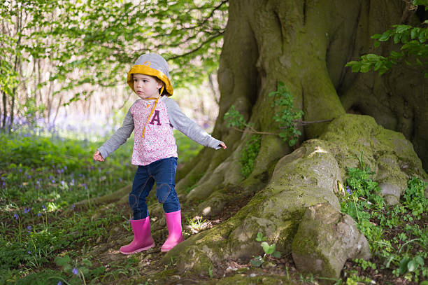 3-year old girl playing in a forest during springtime in Kent, United Kingdom.