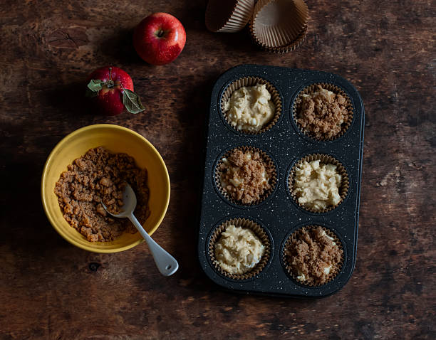 istock Making muffins with apples and cinnamon crumble on a wooden table, top view 2242926960