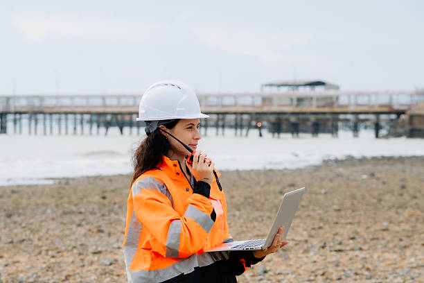 istock She is standing on a beach. Female engineer or supervisor in safety helmet and PPE at an industrial construction site or energy plant. 2242930663