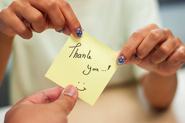 A close-up shot capturing a heartfelt thank you note exchange between colleagues.