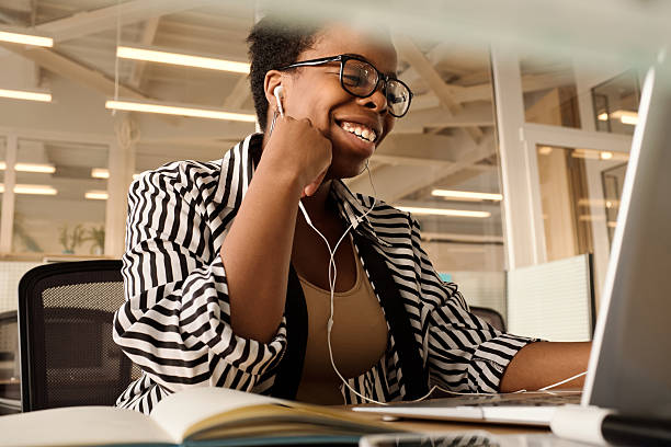 istock Female Employee Wearing Earbuds Video Chatting on Laptop 2242933012