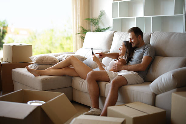 istock Happy couple resting while moving home checking phone 2242935315