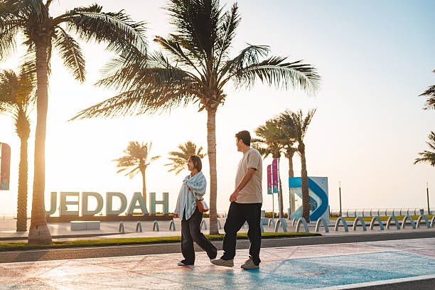 istock Young Couple Strolling by Seaside Promenade at Sunset 2242938582