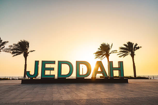 istock Serene Sunset Behind Iconic Jeddah Sign and Palm Trees 2242938604