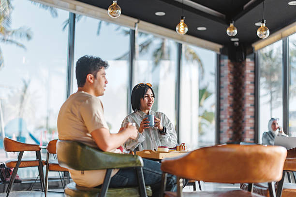 istock Relaxed Friends Conversing Over Coffee in Cozy Cafe 2242939036