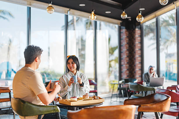 istock Engaged Diverse Young Adults Chatting in Bright Cafe 2242939091