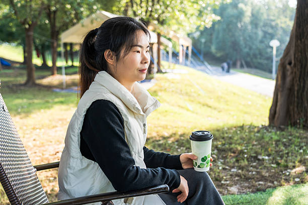 istock A woman sitting outdoors holding a coffee cup enjoying the scenery 2242939189