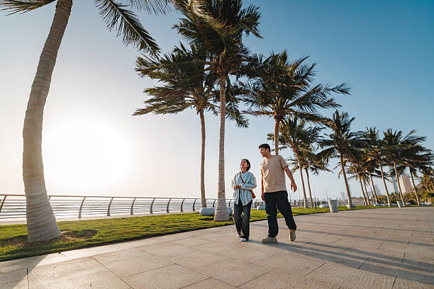 istock Delighted Couple Strolling Beneath Tall Palm Trees Together 2242939202