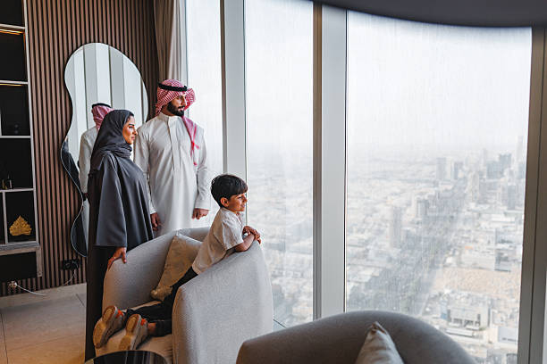 istock Middle Eastern Family Admiring Panoramic Riyadh Cityscape Through Luxury Apartment Window 2242940024