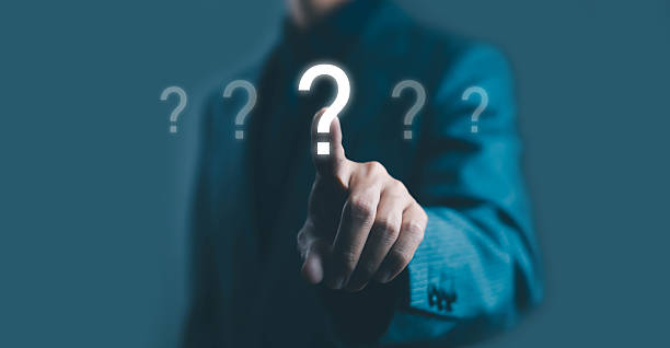 istock Businessman pointing at a glowing question mark icon on virtual screen, symbolizing decision making, problem solving, innovation, and inquiry in business strategy concept. 2242942296