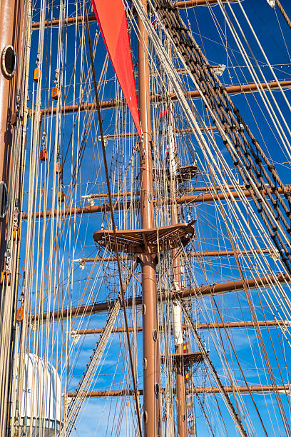 istock Vintage tall ship with red sail and intricate rigging against blue sky 2242942810