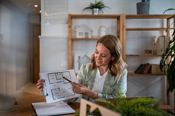 istock Real estate agent explaining home blueprint to client 2242944075