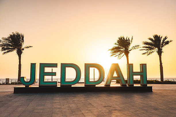 istock Serene Sunset Behind Iconic Jeddah Sign and Palm Trees 2242944225