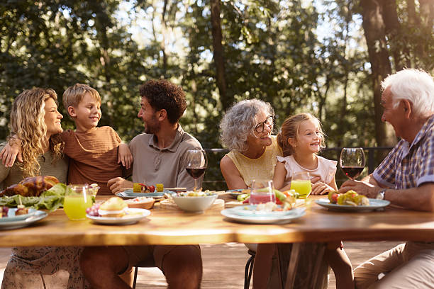 istock Happy extended family talking during lunch at picnic table. 2242947150