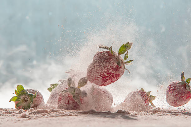 strawberries in motion, jumping in powdered sugar