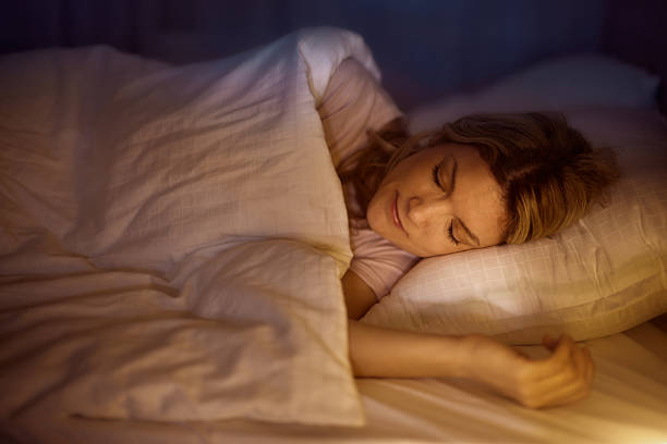 Asian young woman on the bed in the bedroom trying to wake up and prepare for work
