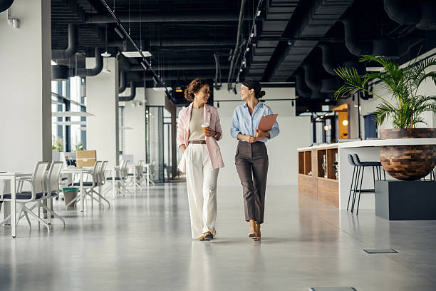 istock Businesswomen walking and talking in modern office 2242952042